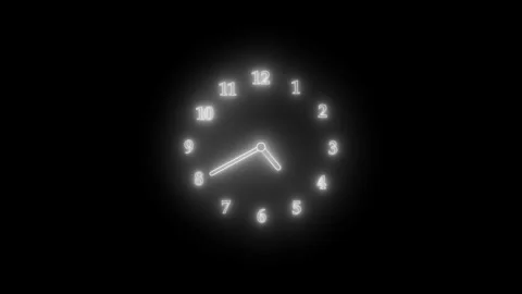 A glowing neon clock face with white numbers and hands on a black background. Stock Footage 304395795