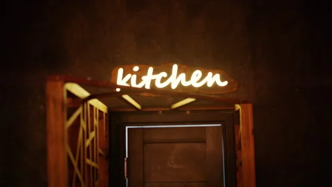 Glowing neon sign reading kitchen above a doorway in a warm interior setting Vídeo Stock 332592193