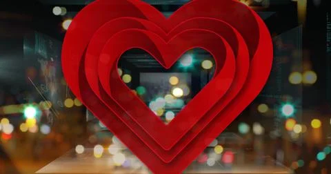 Glowing nested red hearts reflecting on mirror on street at night with bokeh 写真素材