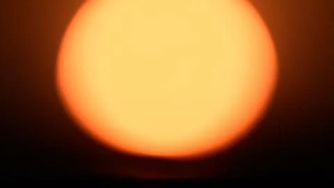 Glowing orb of the sun during sunset close-up. Out of focus Sun Stock Photos