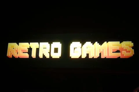 Glowing pixelated text spells Retro Games across a dark screen Stock Illustration