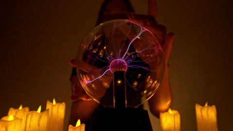 Glowing plasma ball held by fortune teller in candlelit divination session Stock Footage 295857985