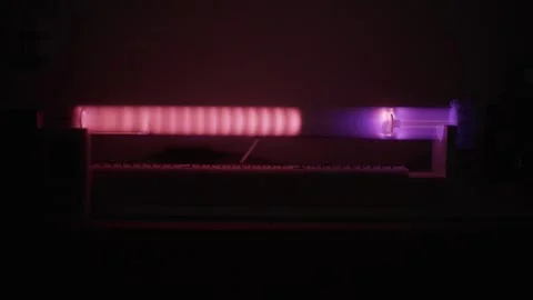 Glowing pulsed plasma test in a glass tube inside a dark laboratory Stock Footage 338181667