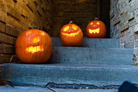 Glowing Pumpkins Sit on Outdoor Steps Stock Photos
