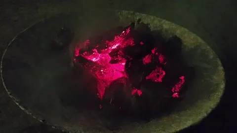 Glowing red embers and burning charcoal in a traditional fire pit at night, crea Stock Footage 341827111
