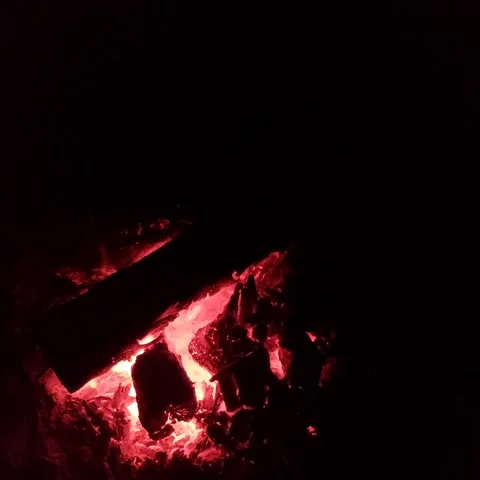 Glowing red embers and charred wood in dark fireplace. Stock Footage 346223785