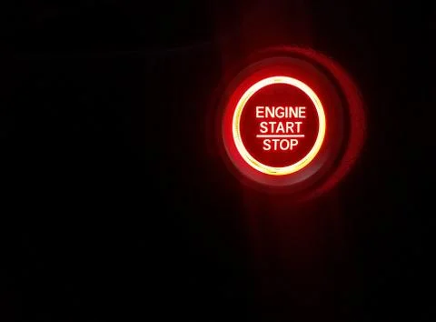 Glowing red engine start stop light and black background Stock Photos