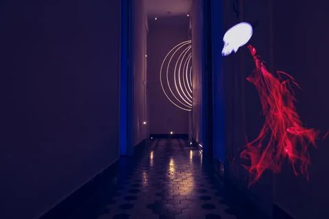 Glowing red ghostly skull floating in a dark hallway illuminated by geometr.. Stock Photos