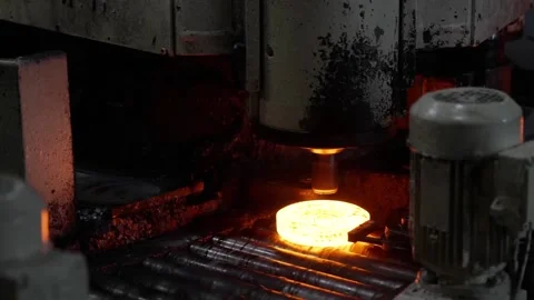 Glowing red-hot metal ring being positioned on a roller conveyor by an Vidéo 332917819