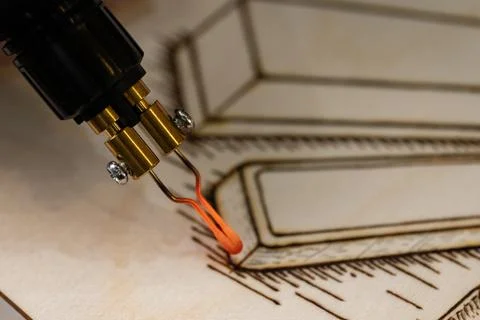 Glowing red hot tip of pyrography pen burning wood Stock-Fotos