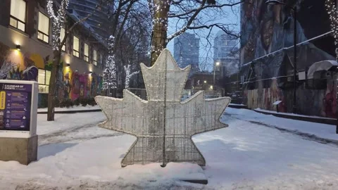 Glowing red maple leaf illuminating a snowy Toronto street Stock Footage 327992746
