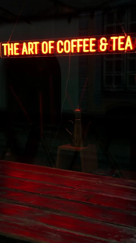 Glowing red neon coffee tea sign inside dark storefront window with rustic Stock Footage 337735772