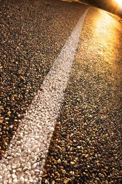 Glowing road at sunset with sun rays Stock Photos