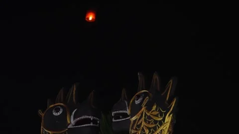 Glowing Sky Lantern Above Thai Temple Statues at Night Stock Footage 327712198