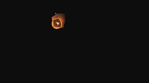 Glowing Sky Lantern Soaring Through the Night Sky During Cultural Festival Stock Footage 267580718