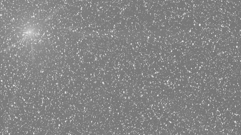 Glowing sparkles drifting gently through falling snow scene 库存影片 336314064