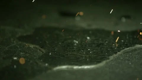 Glowing sparks bouncing and dancing on wet dark stone Stock Footage 327631819