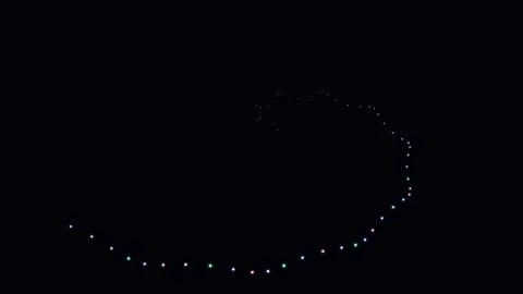 A glowing spiral pattern of small bright lights against a deep black backgrou 库存影片 338310593