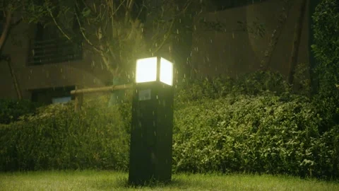 Glowing Square Garden Lamp Post Illuminated in Heavy Rainy Night Видео 337409258