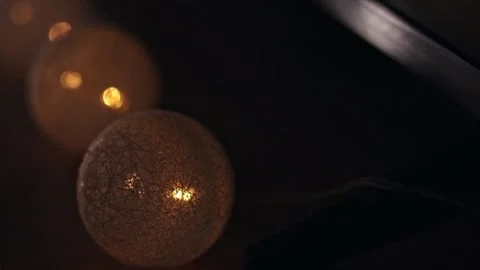 Glowing string lights with decorative thread balls, warm bokeh at night 動画素材 346304466