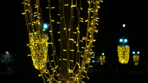 Glowing string lights hanging on a pole at night Stock Footage 318349411