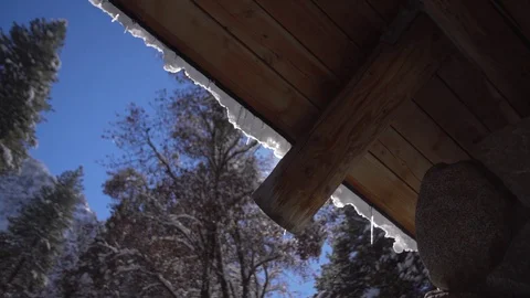 The glowing sun could be seen from under the snowy wooden roof Stock Footage 127613255