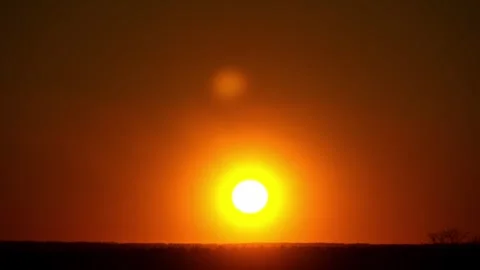 Glowing Sun Setting Behind Silhouetted Forest Horizon Stock Footage 329608758