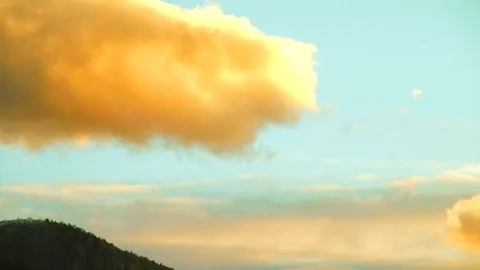 Glowing sunset clouds hover above majestic mountains and lonely pine forests. Stock Footage 88405080