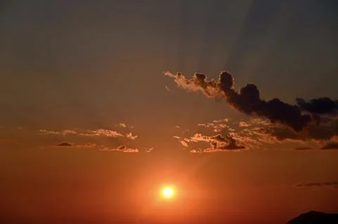 Glowing sunset sky with dramatic clouds and sunbeams Stock Photos