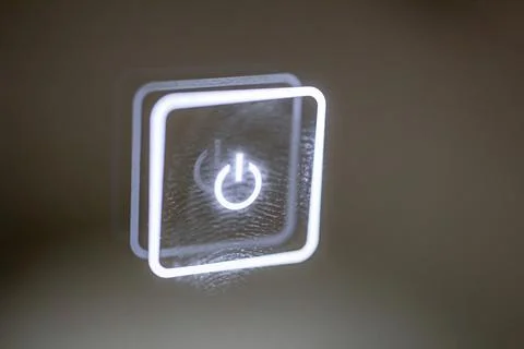 A glowing touch button stained with finger marks. turn on off. Stock Photos
