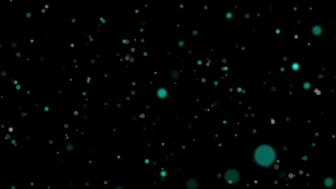 Glowing turquoise and white particles float in motion against a dark background 스톡 동영상 331609980