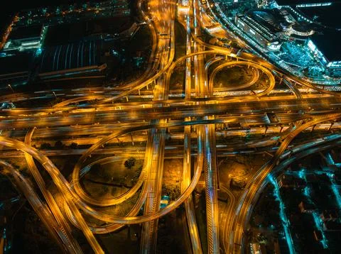 Glowing Vehicle Light Trails On Multi-level Highway Interchange At Night Hi.. 库存照片