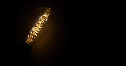 Glowing Vintage Light Bulb on Black Background. Flickering Light Bulb 動画素材 125318890