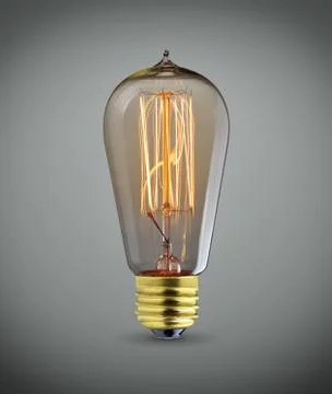 Glowing vintage  light bulb over gray background Stock Photos