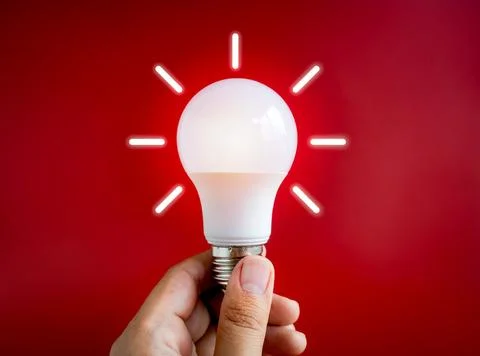 Glowing white light bulb with graphic radius neon style, holding by hand is.. Stock Photos