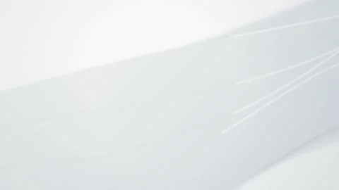 Glowing white lines drift over curved paper sheets in a seamless loop Stock Footage 343324680