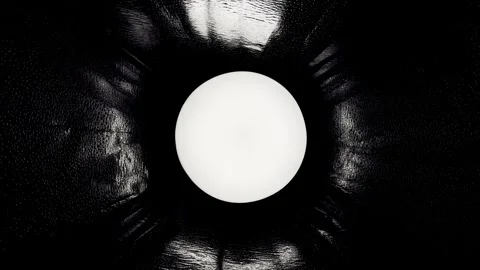 Glowing white sphere illuminates radial folds of textured black leather in drama Stock Footage 330946682