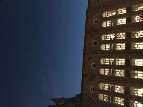 Glowing windows of the building in the evening Stock Photos