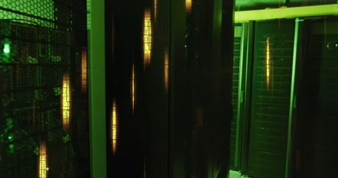 Glowing yellow lights and data processing over green lit, dark computer server Stock Footage 329128281