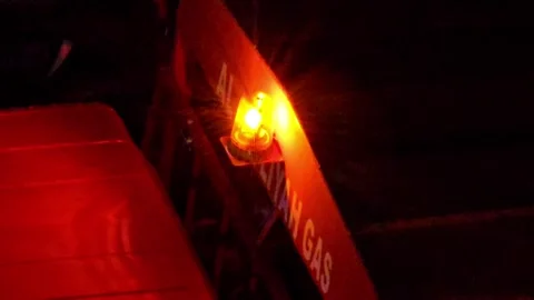 A glowing yellow warning light flashes on a dark red Video stock 311884967