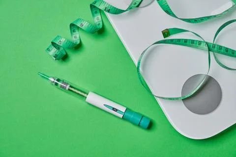 Glp-1 injection pen with scale and measuring tape for weight loss Stock Photos