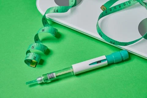Glp-1 injection pen with scale and measuring tape Stock Photos