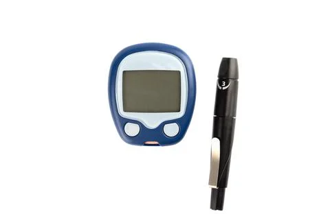 Glucometer and finger lancing device isolated on white background. Stock Photos