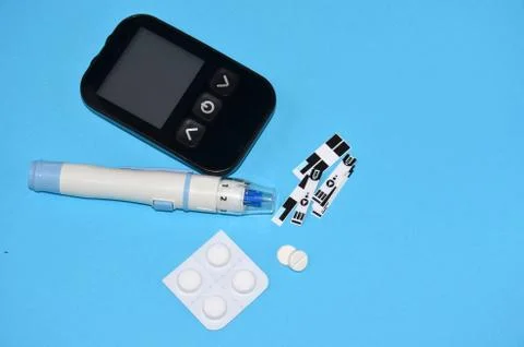 Glucometer and pills on the table.	 Stock Photos