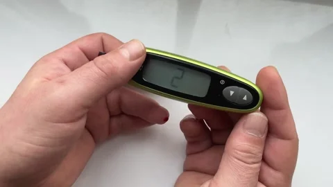 A glucometer in the hands of a man shows a high blood sugar content. The concept Stock Footage 241999696