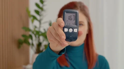 Glucometer reading shows high blood sugar level at 163 mg dL in a home setting Vidéo 334034539