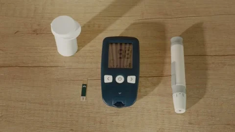 Glucometer shows good glucose level of 98 mg dL on wooden table 스톡 동영상 334033093