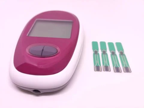 The glucometer with test strips on white background in concept of diabetes, b Stock Photos