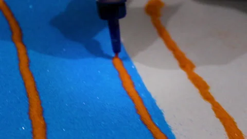 Glue tip drawing orange line in rangoli art Stock Footage 320998842