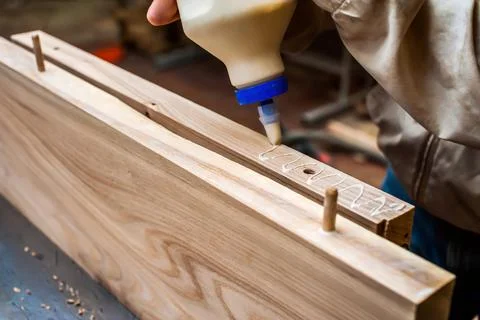 Gluing boards in a carpentry workshop. Connecting with dowels and glue. Manuf Stock Photos